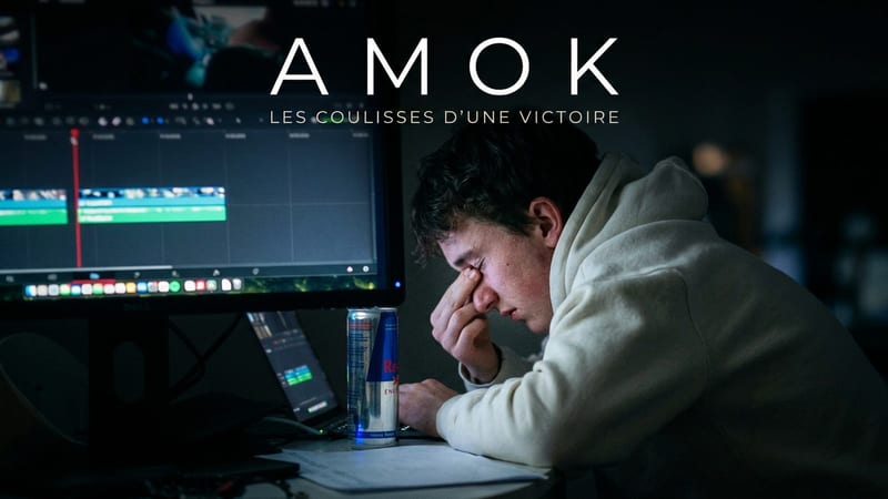 Un monteur épuisé, la tête dans la main, penché sur son banc de montage éclairé par l’écran dans une pièce sombre, une canette posée près du clavier. Titre incrusté : AMOK, les coulisses d’une victoire.